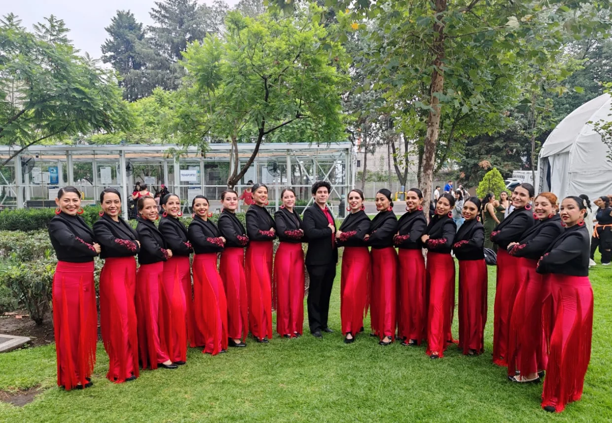 Grupo de danza con vestuario rojo y negro en la fotografía difundida por el INBAL